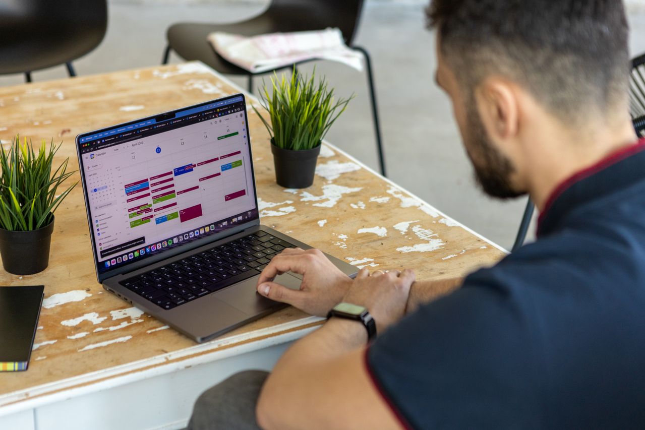 Umbrella contractor reviewing flexible work schedule on laptop calendar, considering guaranteed hours consultation implications